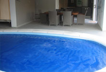 Bâche à bulles bleu sur piscine forme libre